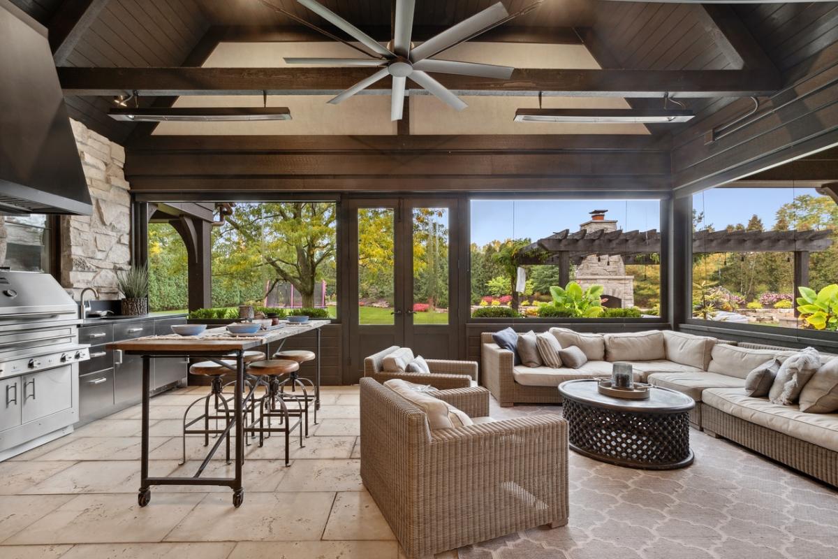 Indoor/outdoor living space with an additional lounge area and kitchenette with gas grill