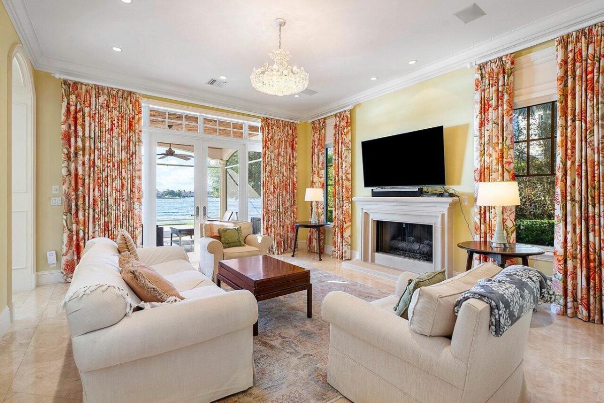 Living room with a chandelier, glass door and a chandelier.