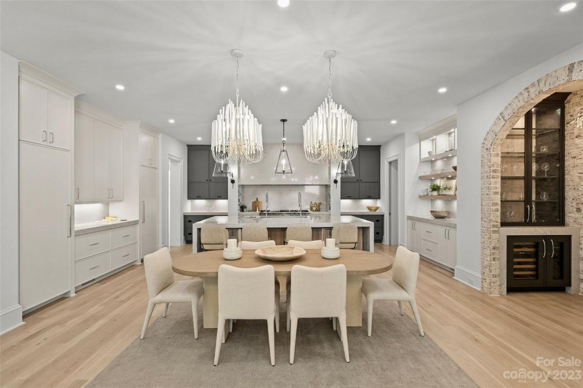 Dining room with chandeliers and hardwood floors.