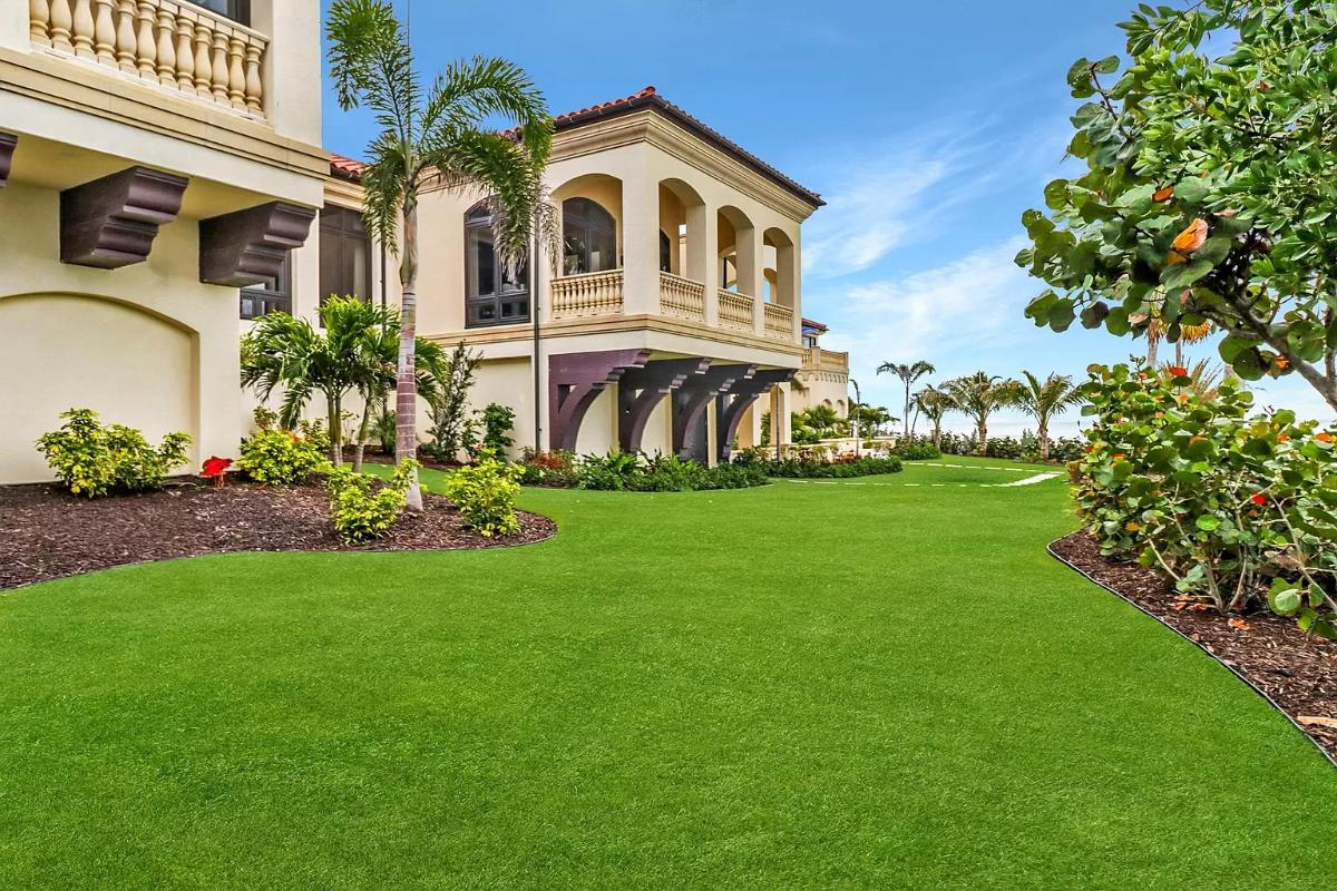 Backyard of the mansion with a huge green lawn.