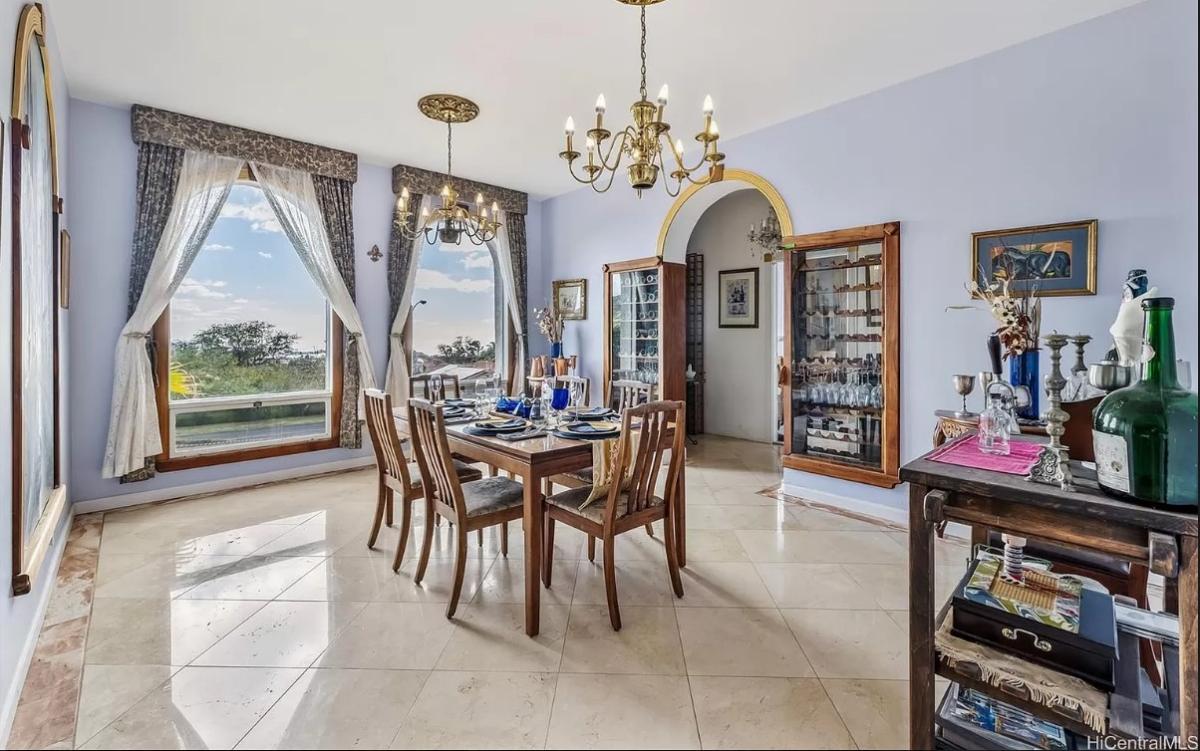 Dining room with wood table, chairs and chandeliers.