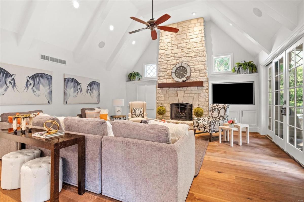 Living room with hardwood floors, high ceilings, and a fireplace.