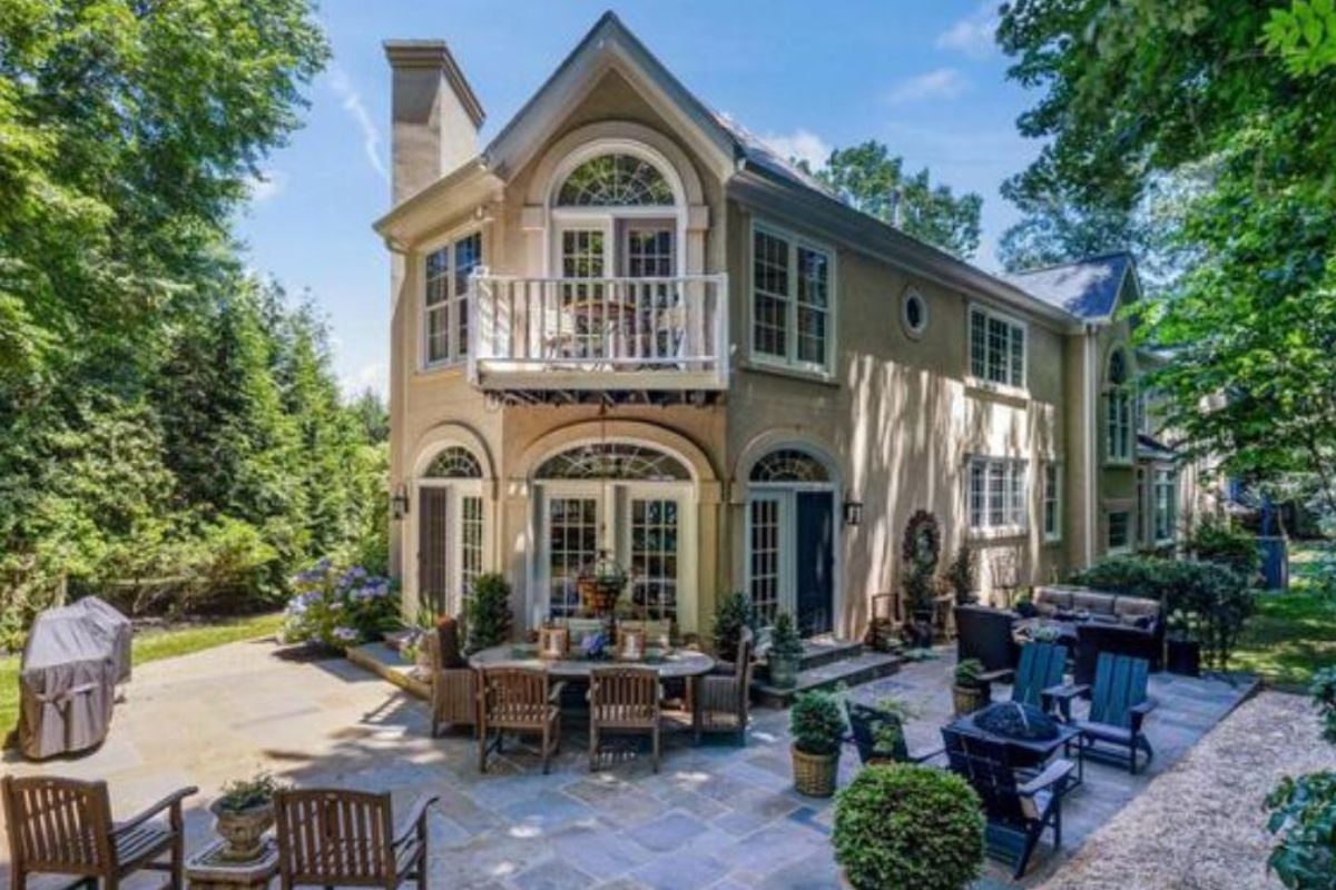 A patio with a table and many chairs.