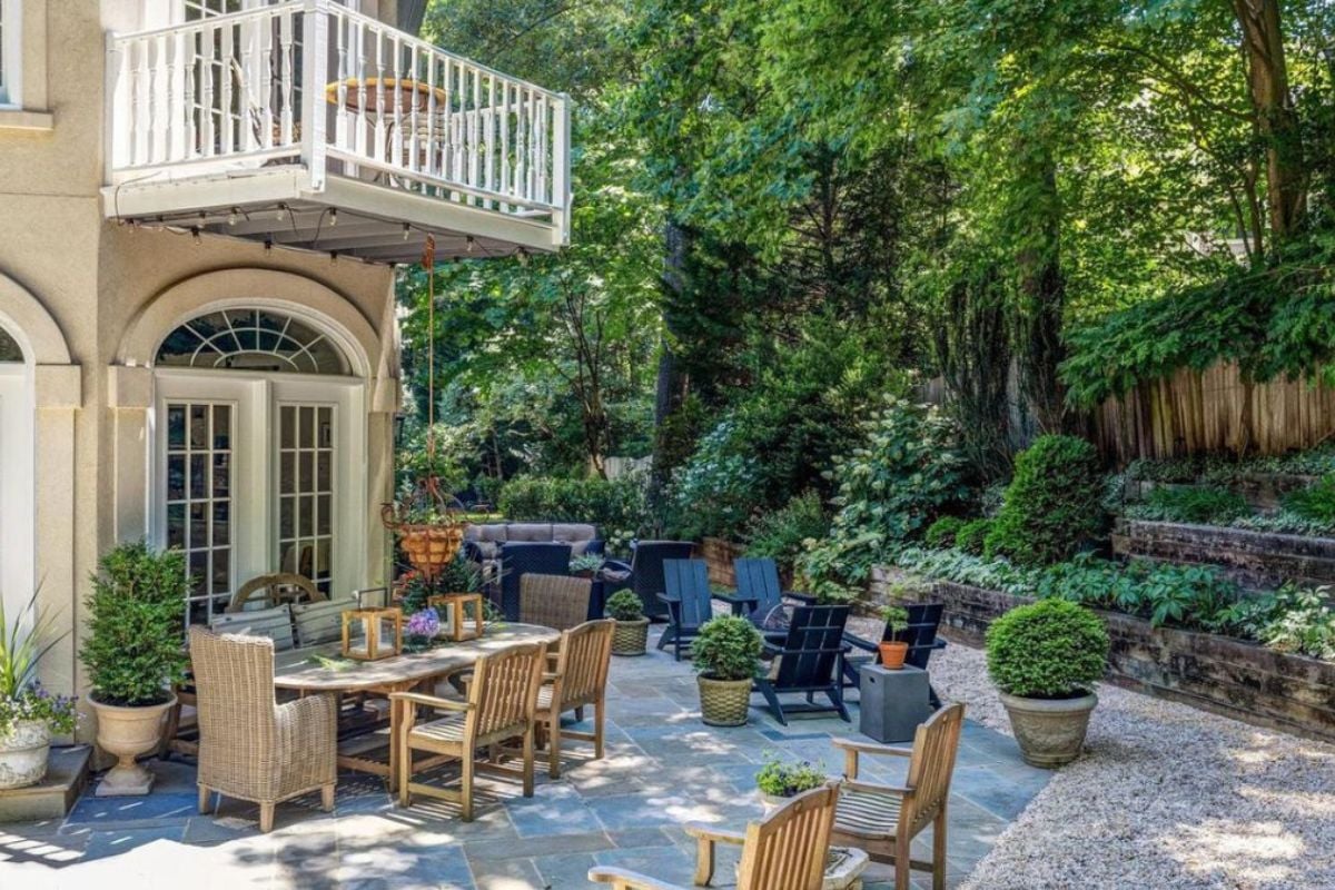 A patio with a table and lots of chairs.
