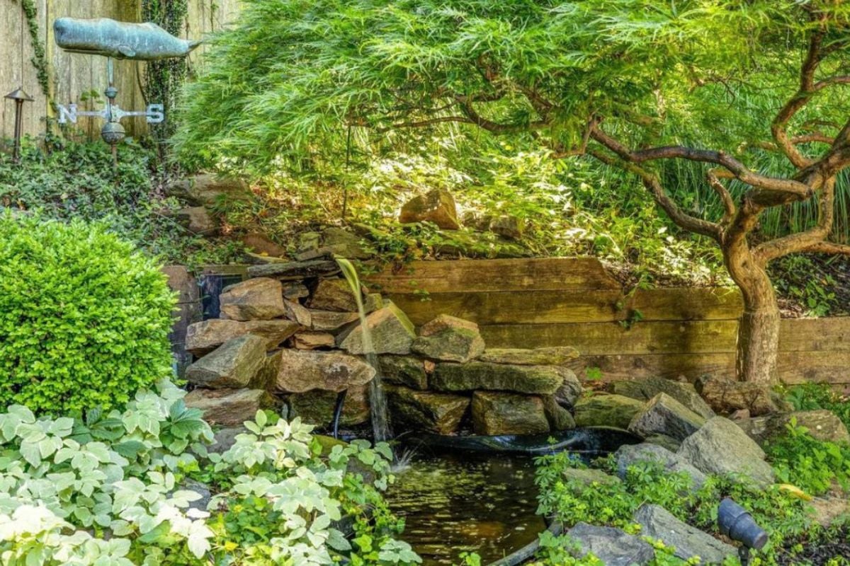 A man-made waterfall surrounded by plants and trees.