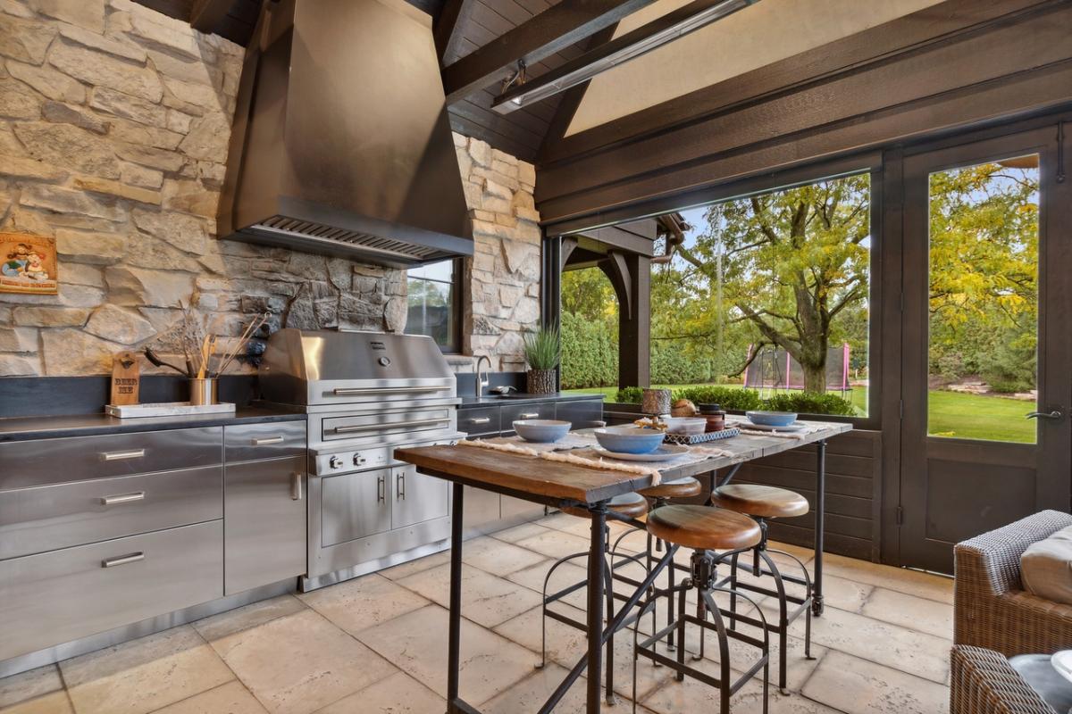 Indoor/outdoor living space with a kitchenette and gas grill
