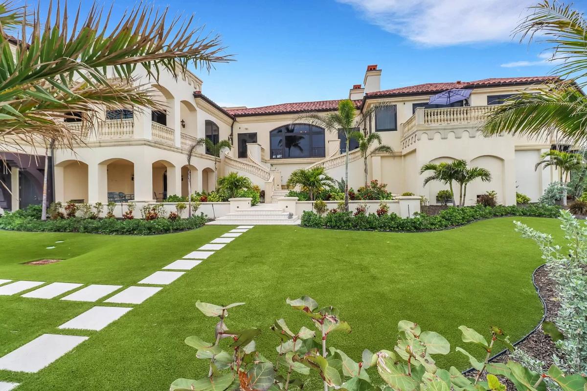 Backyard of the mansion with a huge green lawn.