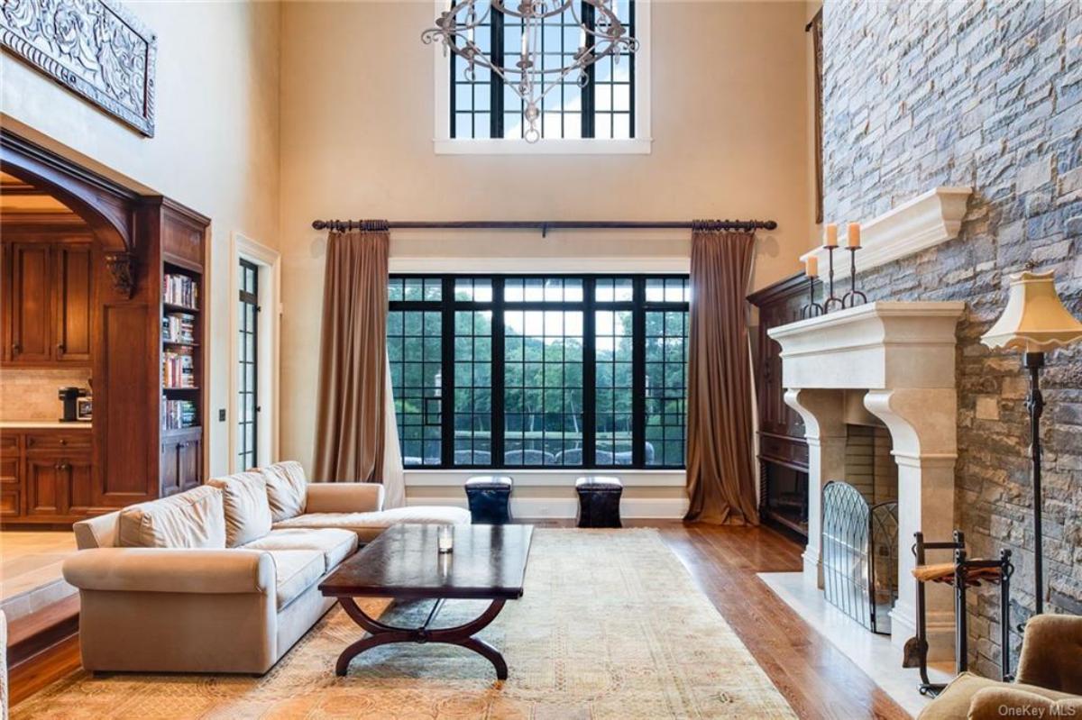 Living room with a fireplace, chandelier and hardwood flooring.