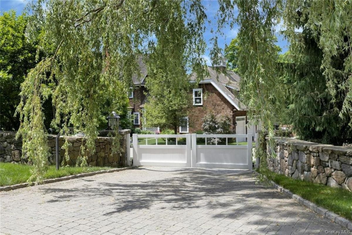 A front gate entry surrounded by trees.