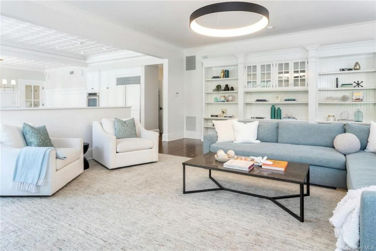 A living room with shelves, a rug, couches, and a center table.
