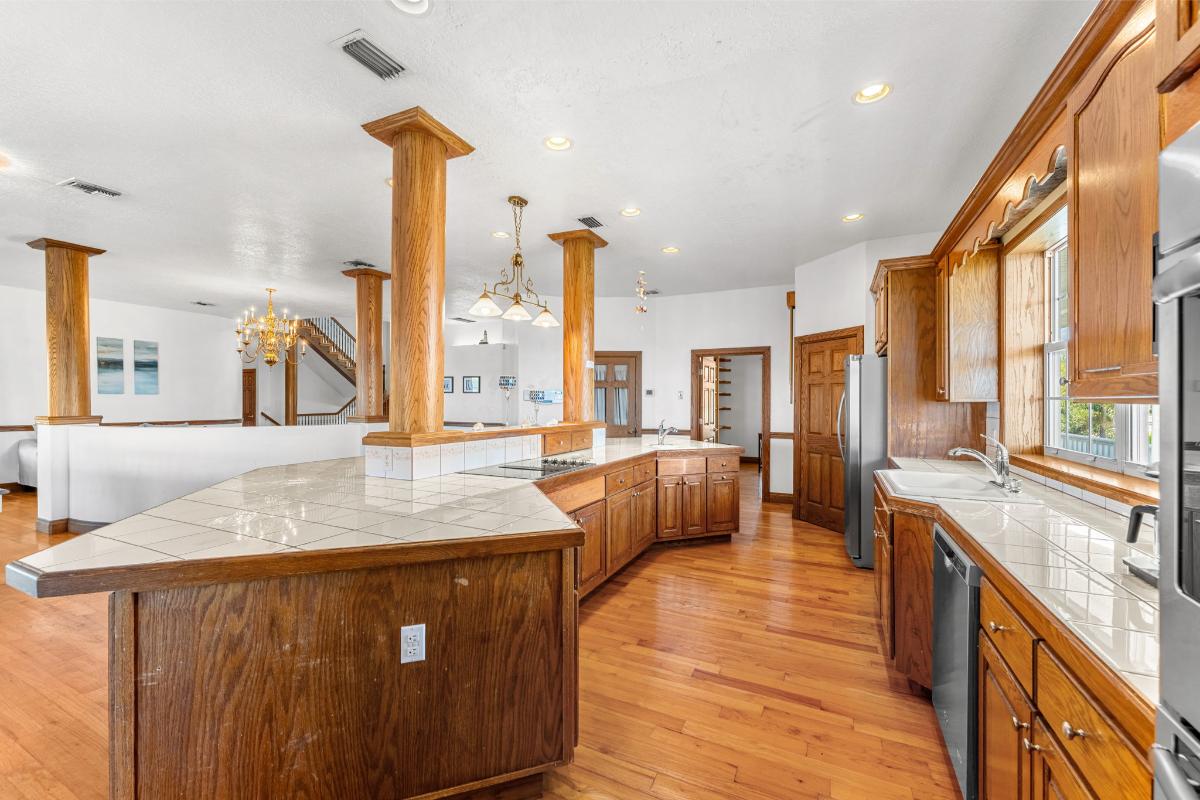 Kitchen with a large island, custom lighting and oak hardwood cabinetry.