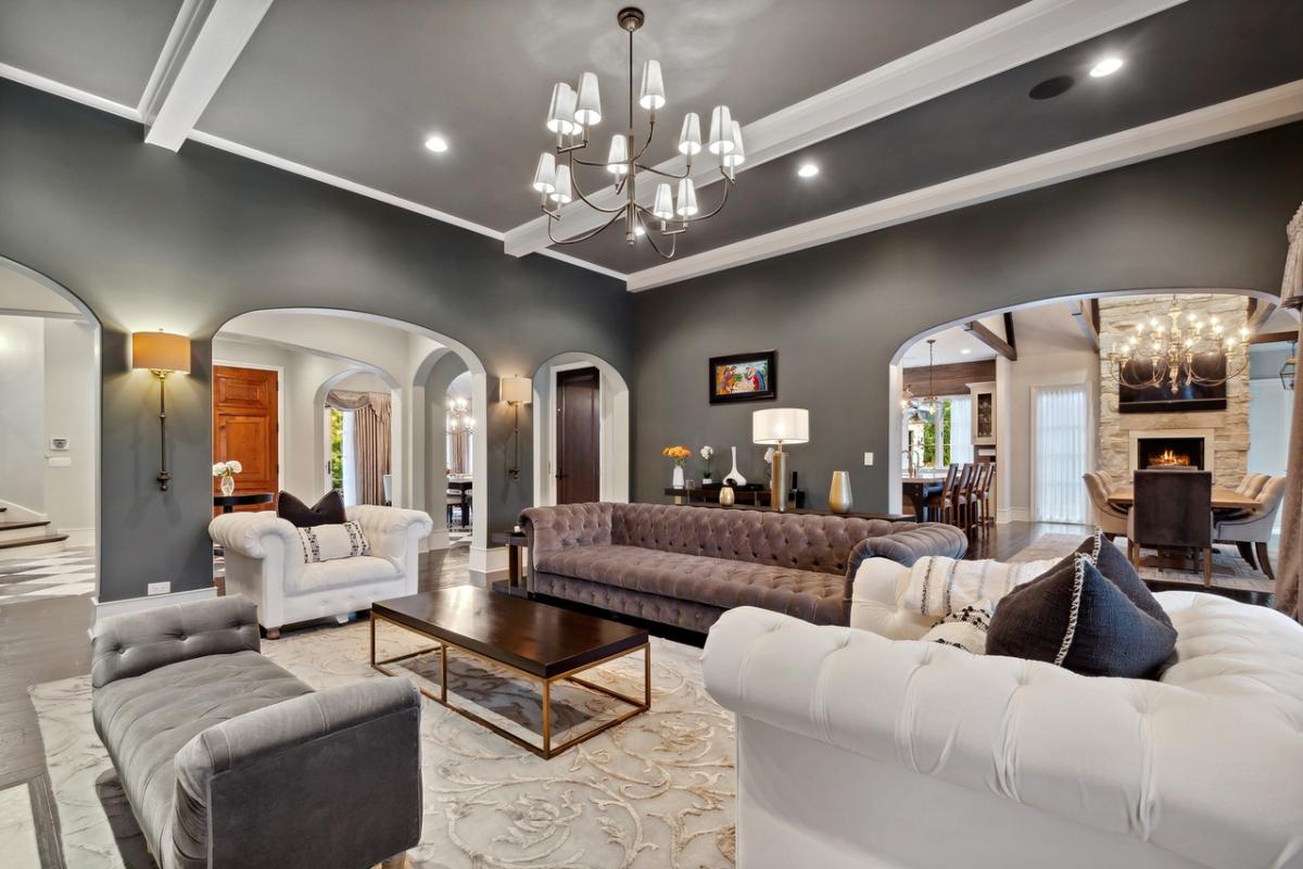 Living room with coffered ceiling, couches and a chandelier.