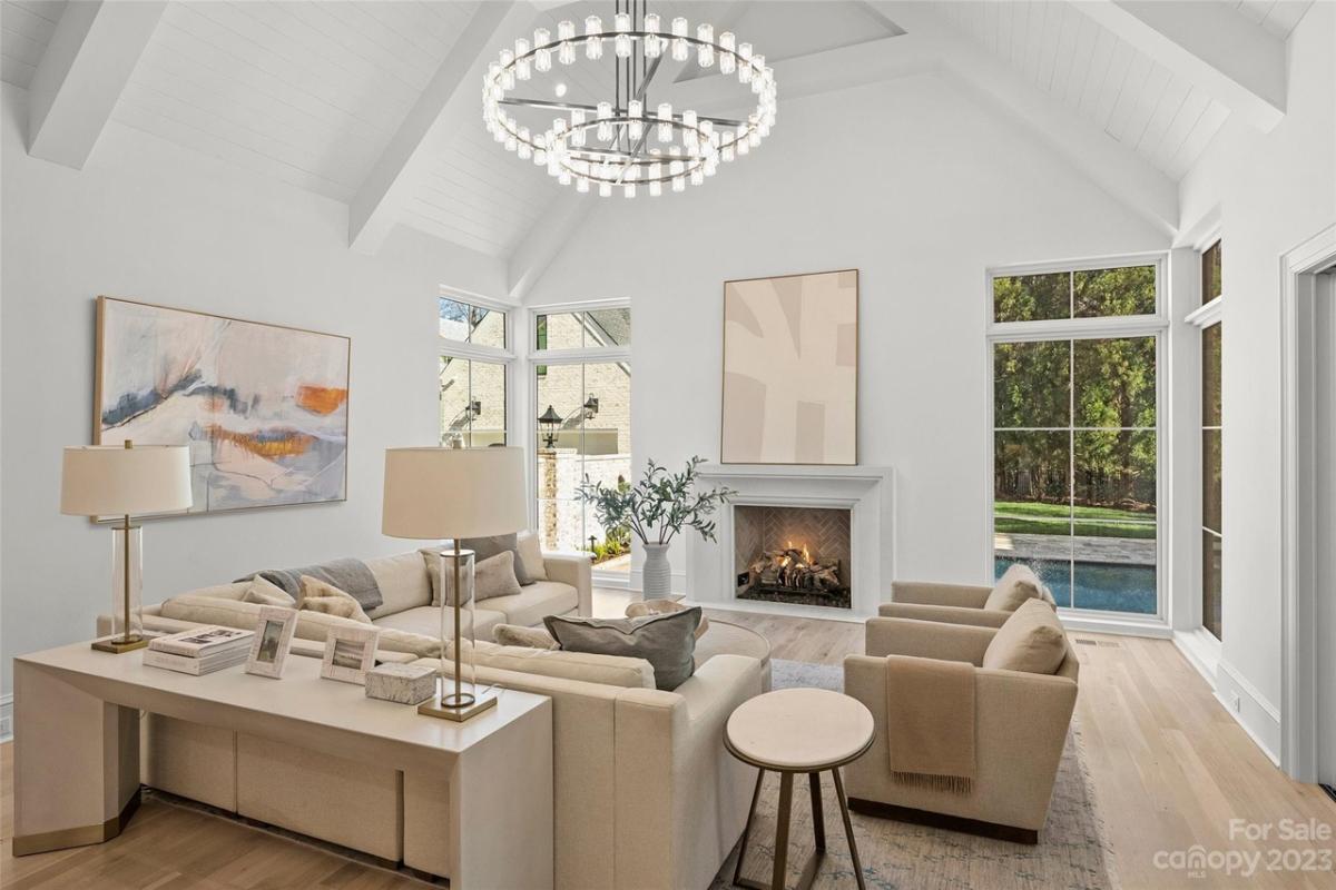 Living room with a chandelier, fireplace and hardwood floors.