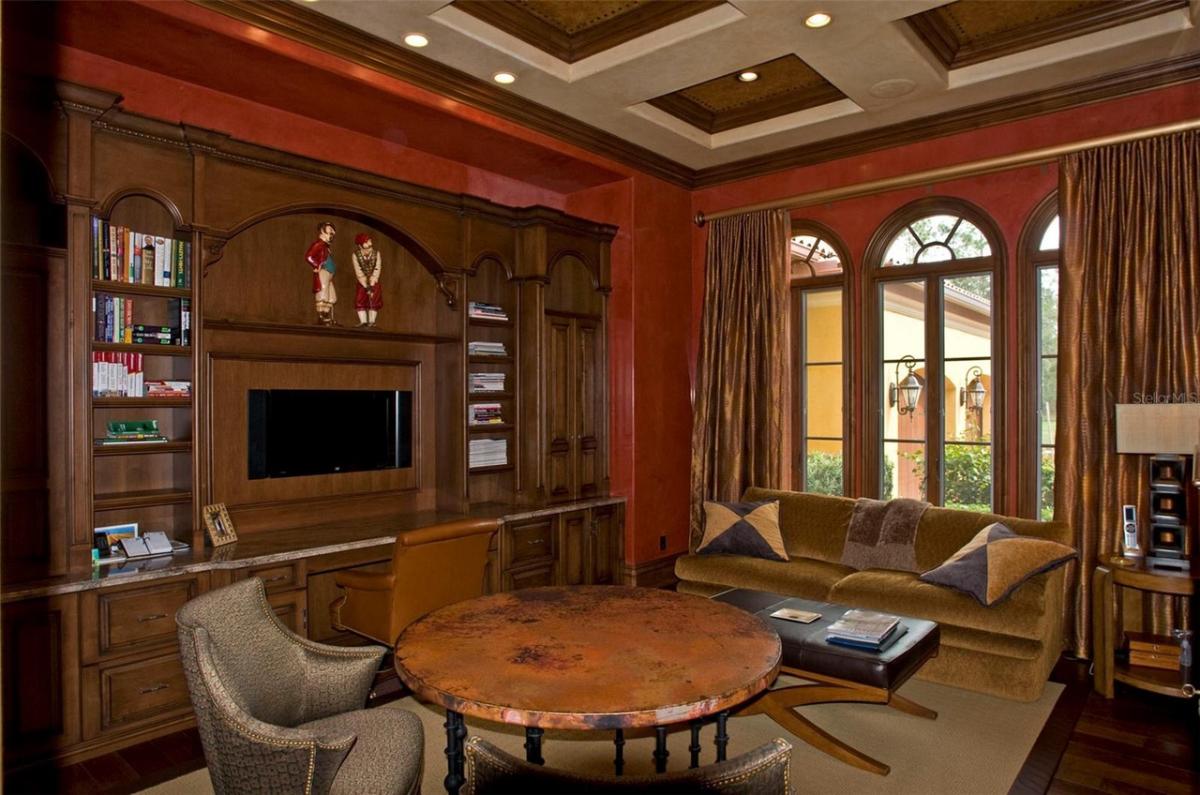 Reading nook with a wood table, couch and bookshelves.