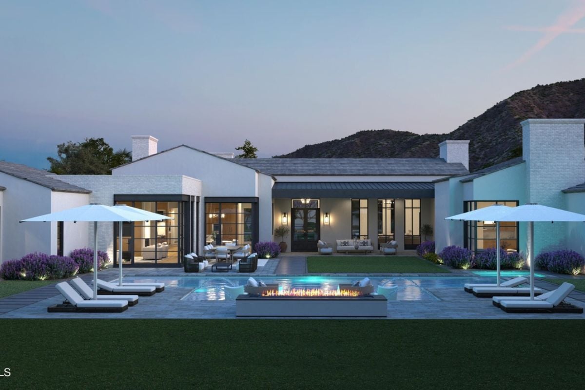 A swimming pool with chairs, umbrellas, and a firepit.