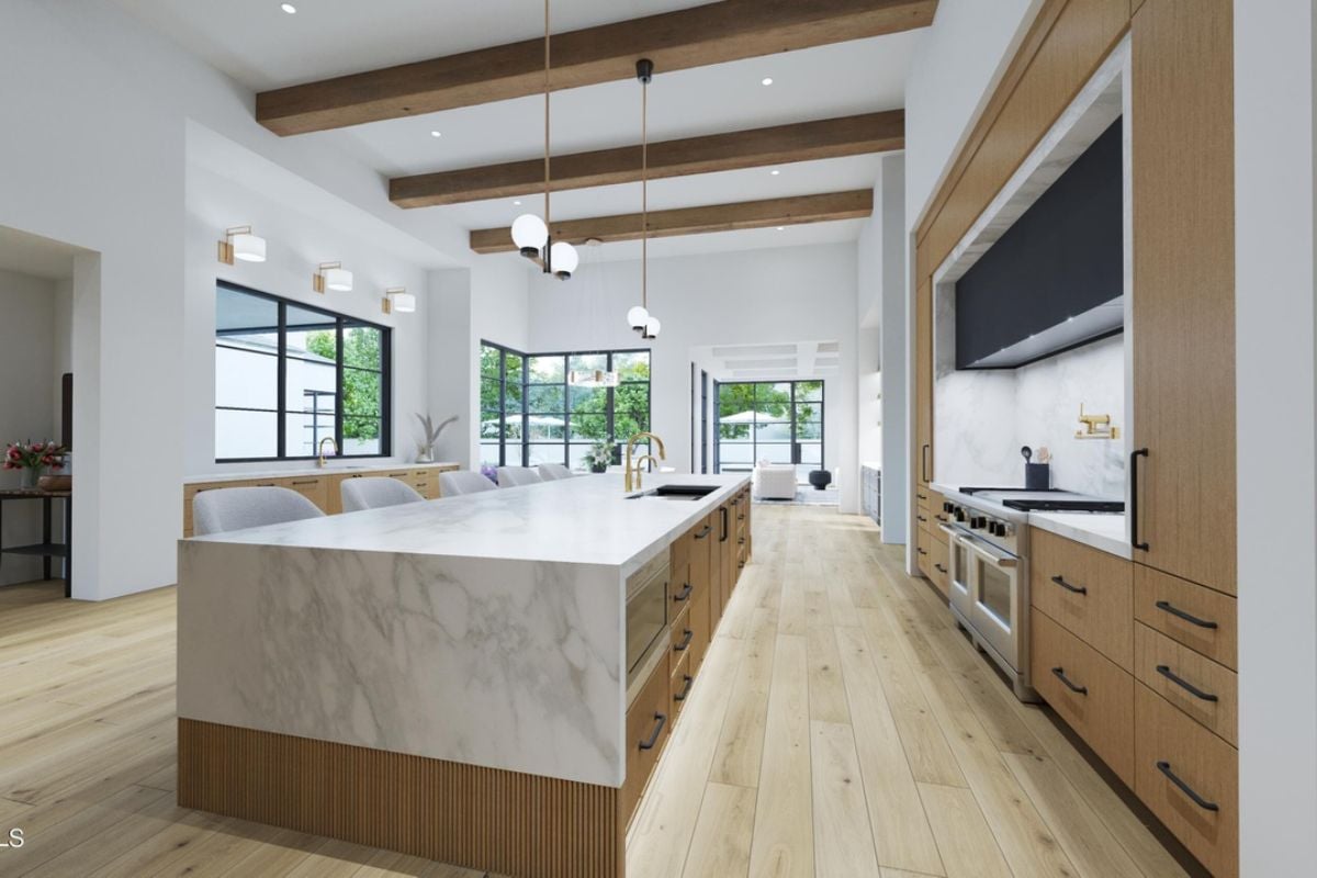 A kitchen with an exposed beam ceiling, countertops, chairs, sink, cabinets, and kitchen appliances.