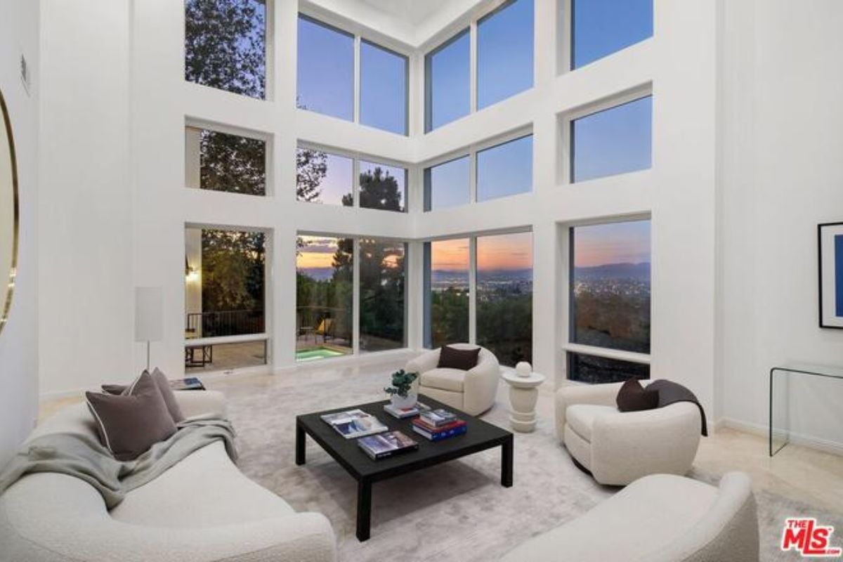 A living room with windows, white couches, and a center table.