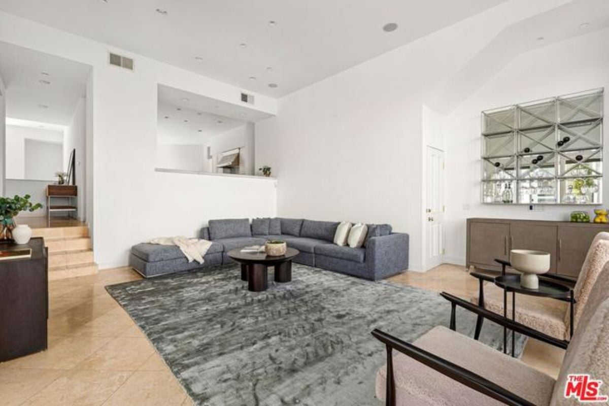 A living room with a rug, chairs, a couch, and a coffee table.