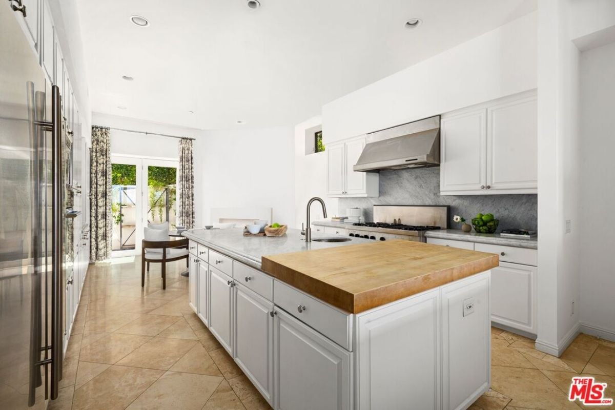 A kitchen with countertops, sink, cabinets, and stove.