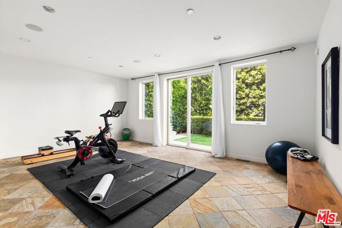 A home gym with a bench and a stationary bicycle.