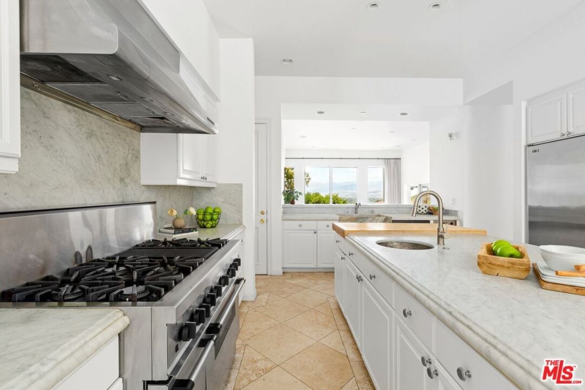 A kitchen with countertops, sink, cabinets, and kitchen appliances.