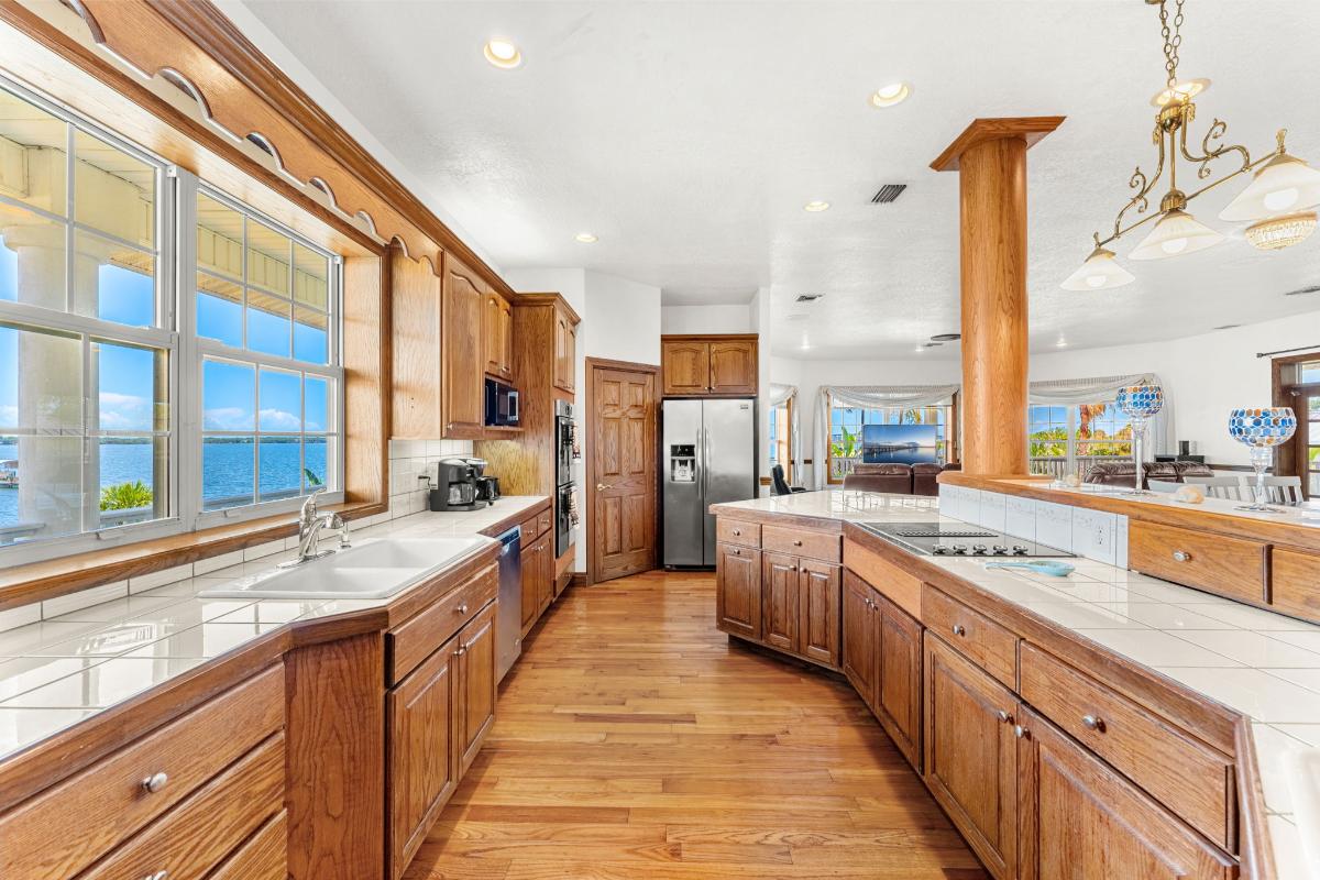 Kitchen with a large island, custom lighting and oak hardwood cabinetry.