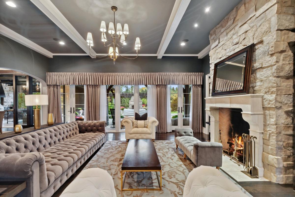 Living room with coffered ceiling, fireplace and a chandelier.
