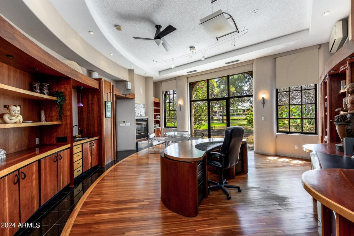 Home office with hardwood flooring, glass doors and glass windows.
