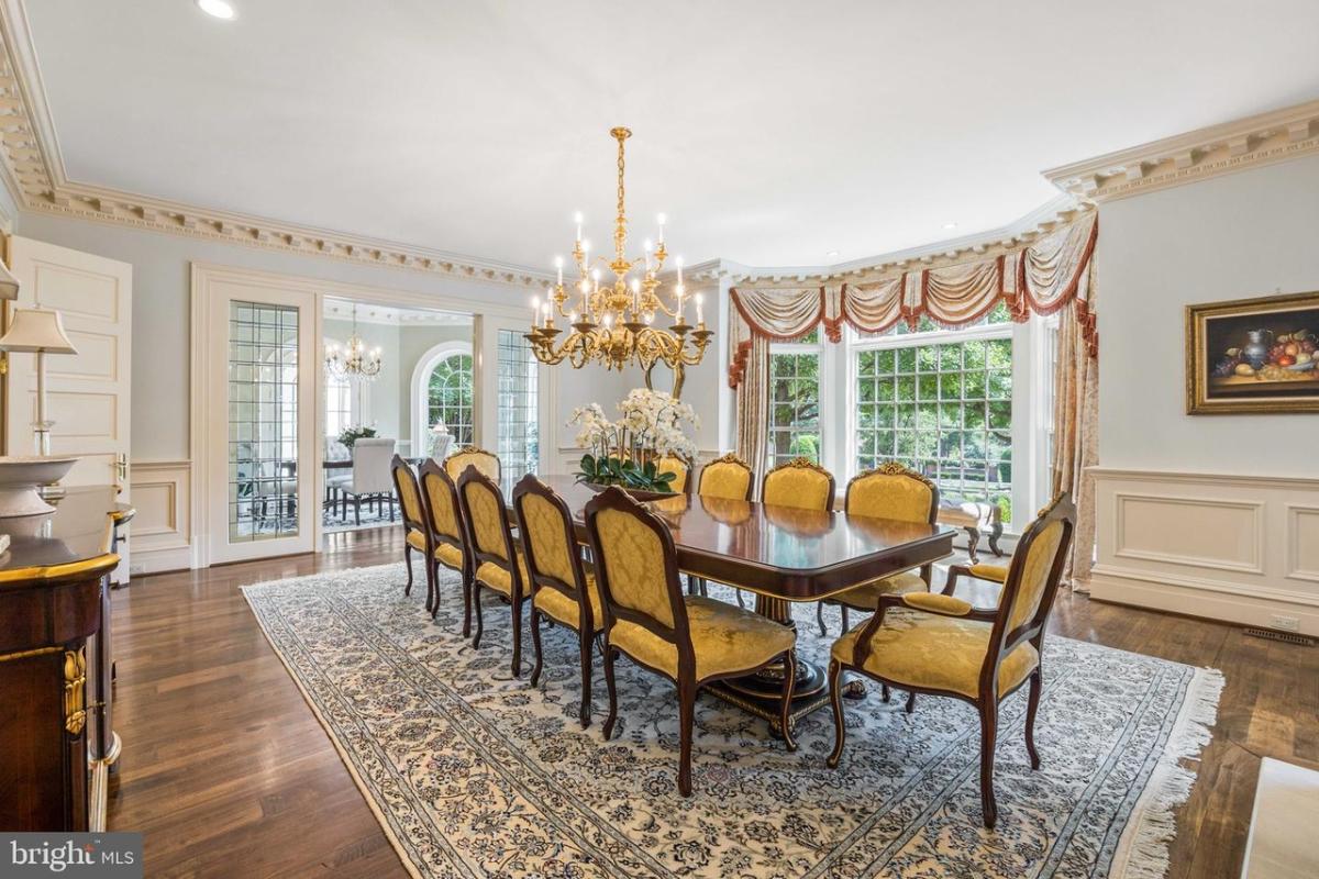 Dining room with hardwood flooring and a chandelier.
