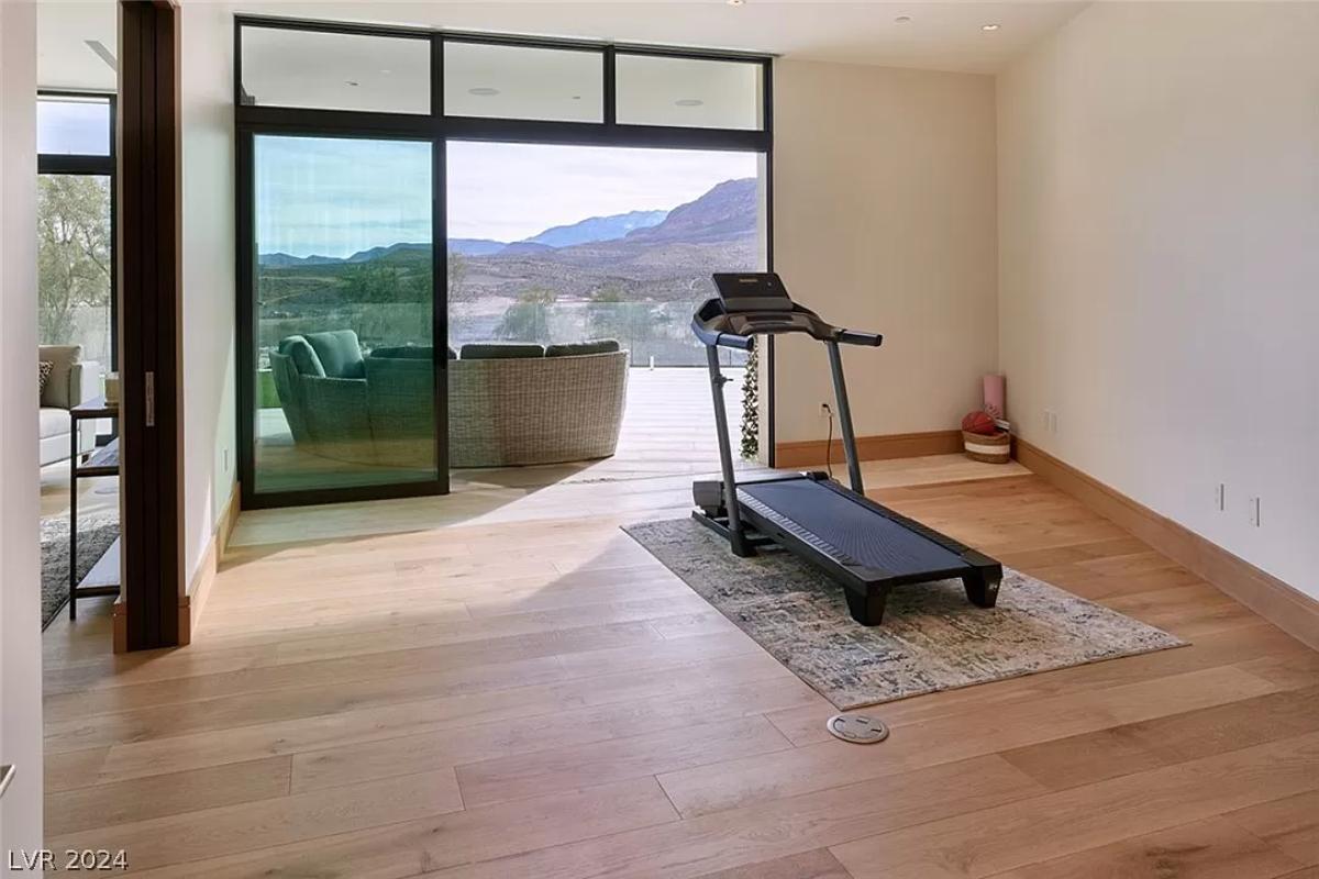 Home gym with wood flooring.