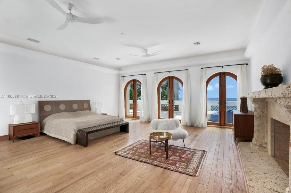 Bedroom with hardwood floors and a fireplace.