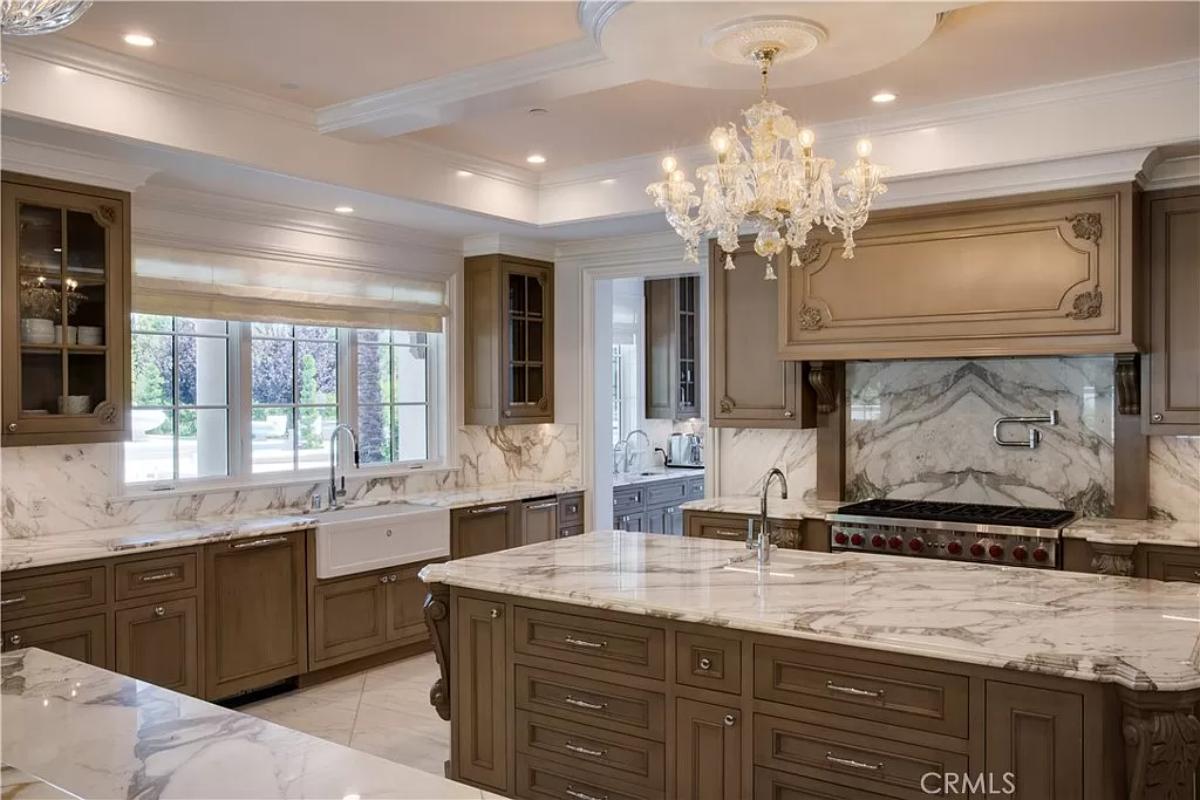 Kitchen with chandeliers, custom cabinetry, and a center island prep area.