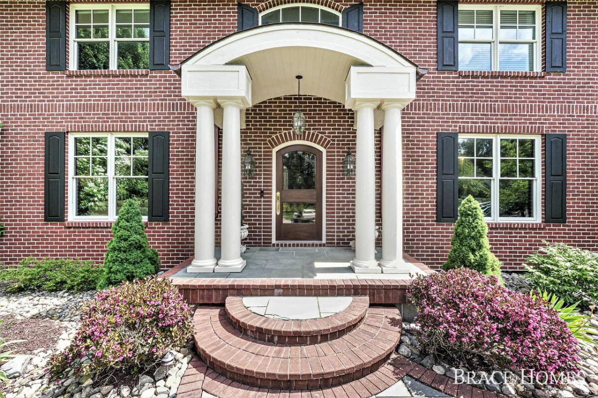 Front entry with double columns, a barrel-vaulted ceiling, and an arched front door.