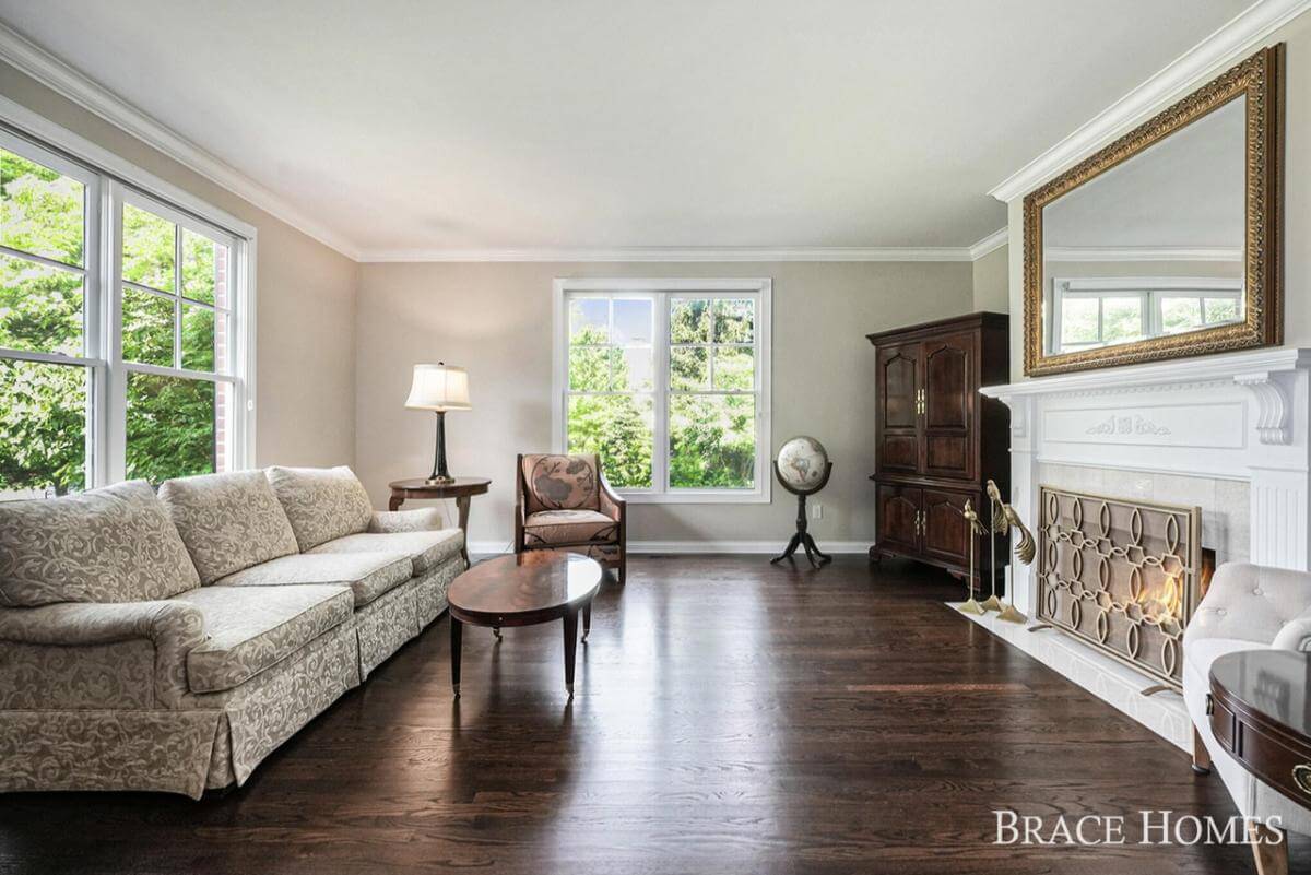 Living room with a skirted sofa and a fireplace topped by a decorative mirror.