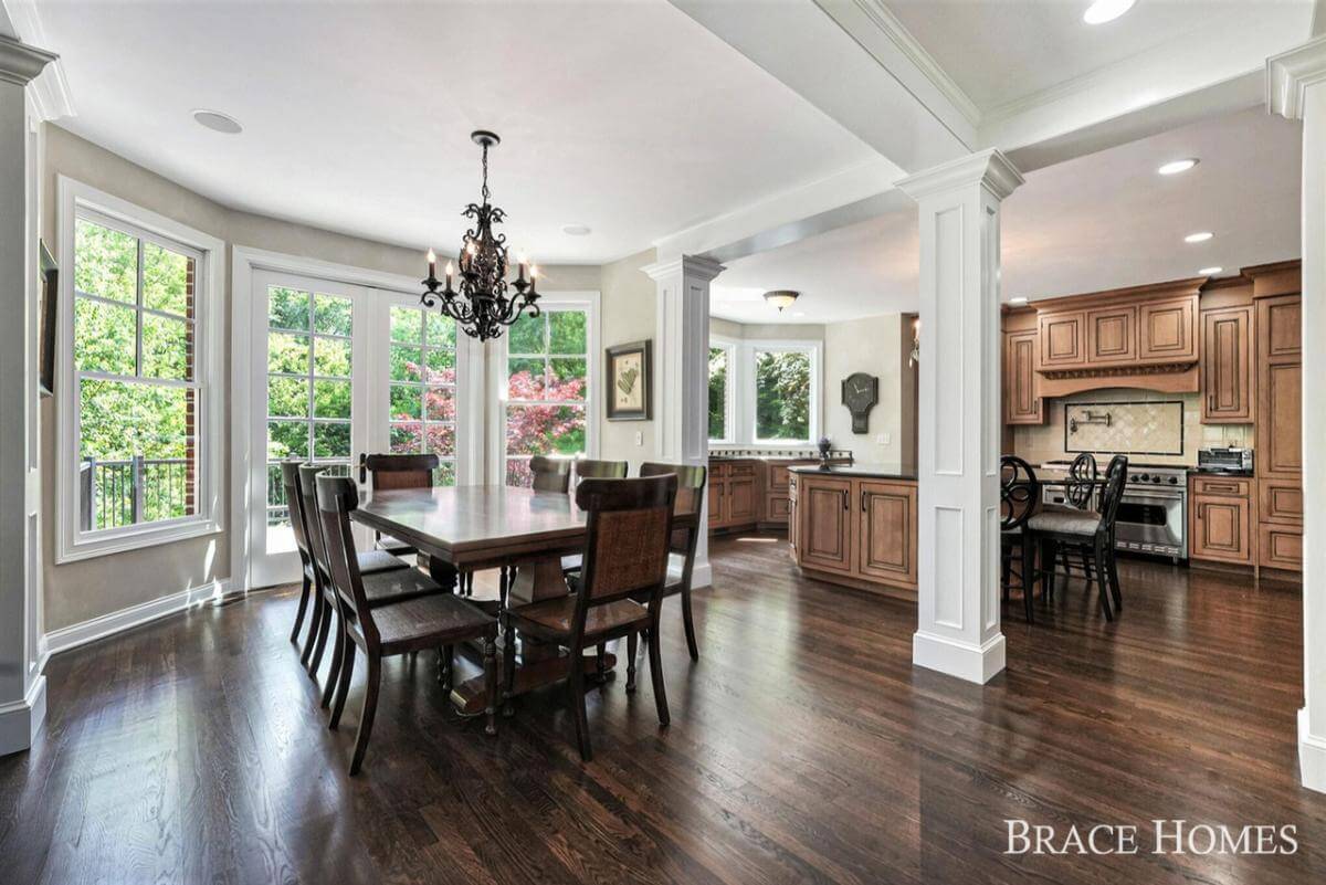 Breakfast nook with a dark wood dining set against the bay window.