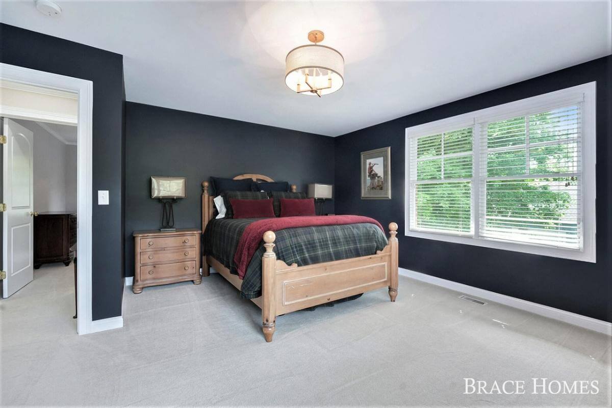 Bedroom with black walls and a wooden bed flanked by matching nightstands.