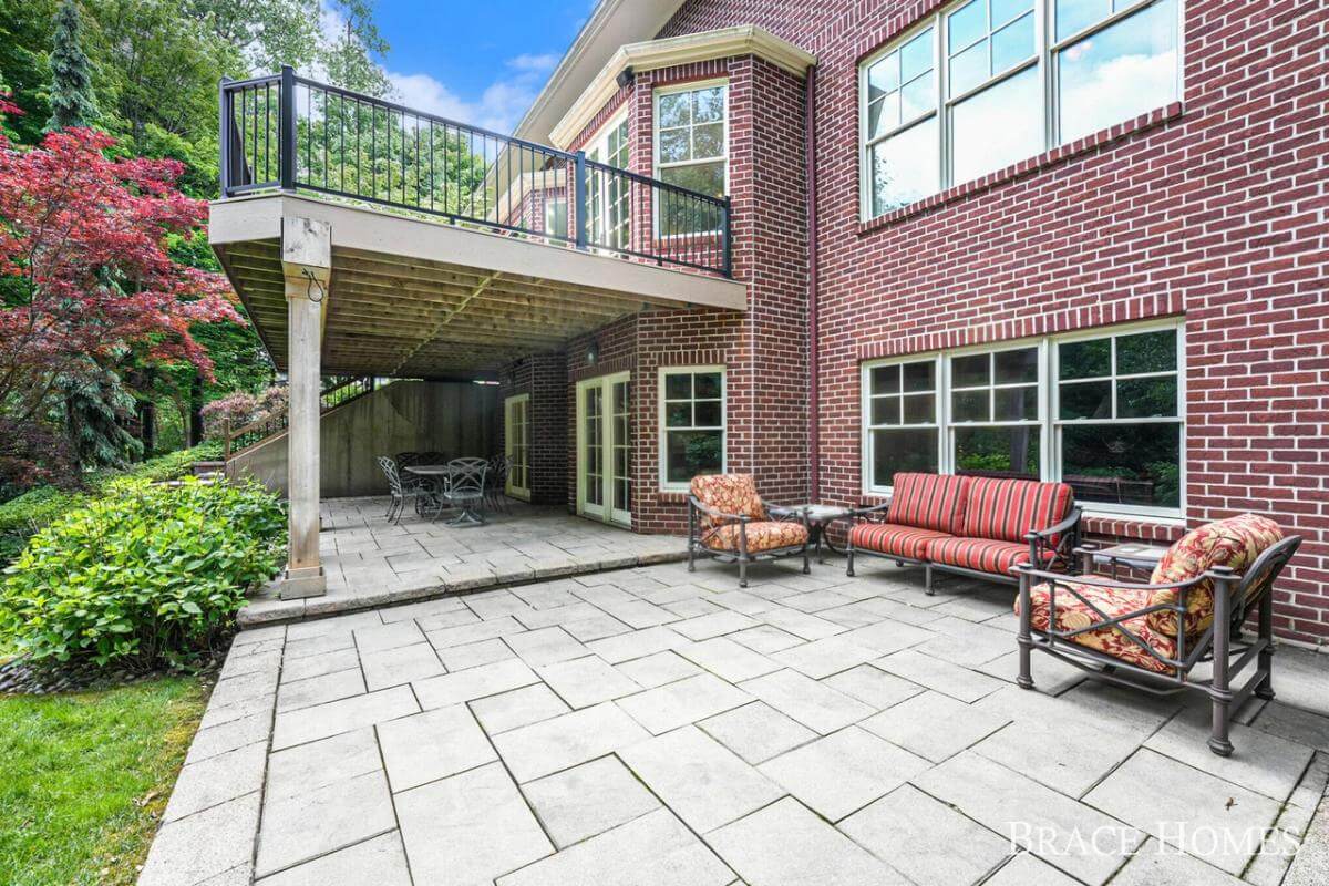 Rear patio with multiple sitting areas over tiled concrete floor.