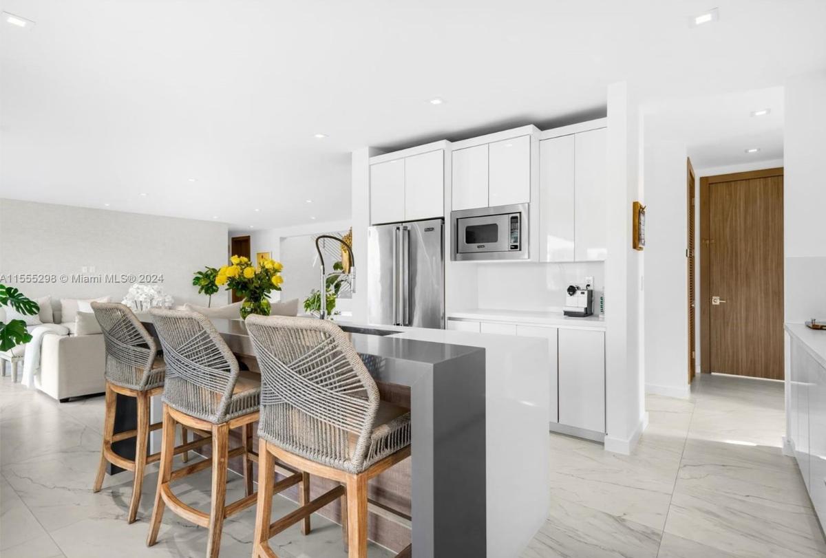 Kitchen with stainless-steel appliances, a spacious counter breakfast bar and a center island prep area.
