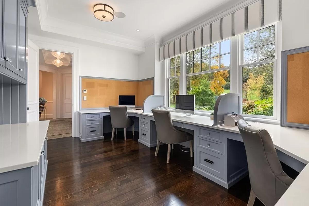Home office with hardwood floors and custom cabinetry.