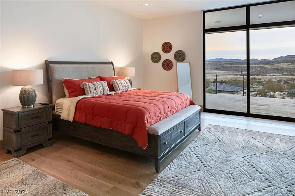 Bedroom with hardwood flooring and sliding glass doors.