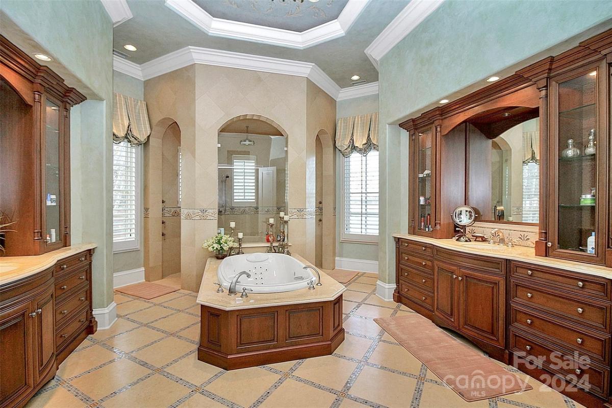 Bathroom with custom-made vanities, walk-in shower and a soaking tub.