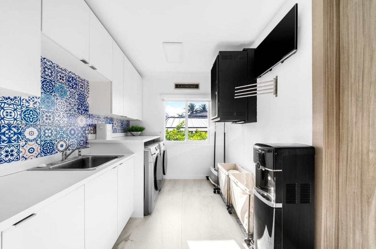 Laundry room with a sink and custom cabinetry.