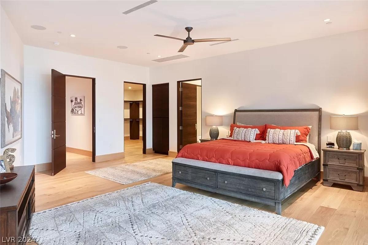 Bedroom with hardwood flooring and a private bathroom.