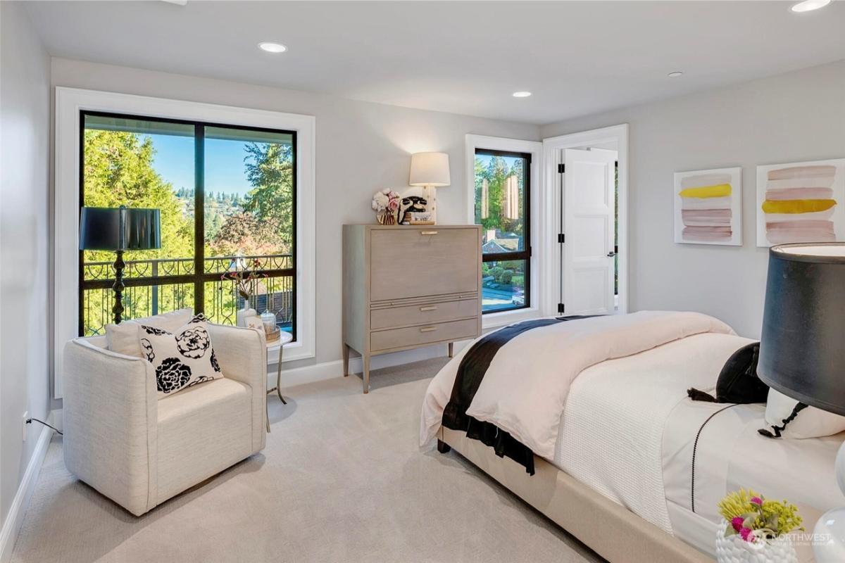 Bedroom with carpet flooring, glass windows and glass doors.