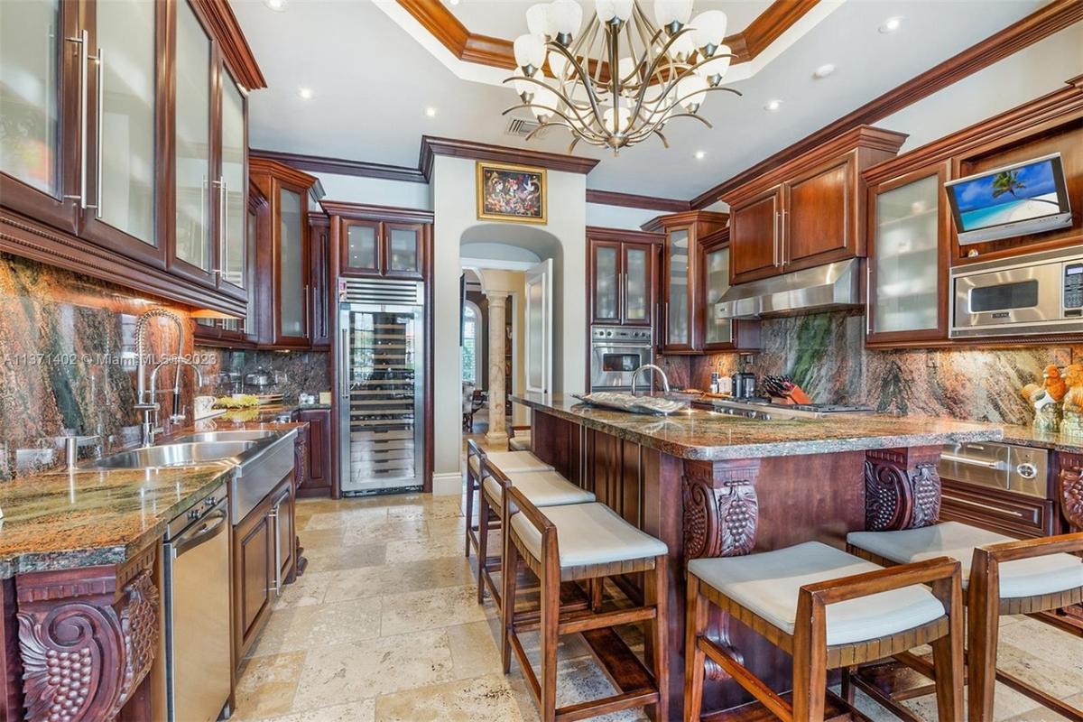 Kitchen with stainless-steel appliances, custom cabinetry and a counter breakfast bar.