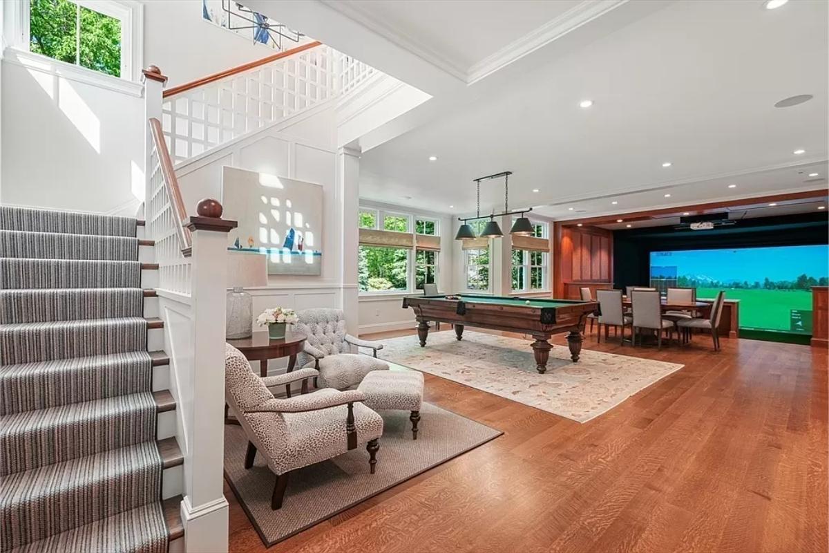 Recreational room with a billiards table and golf simulator.