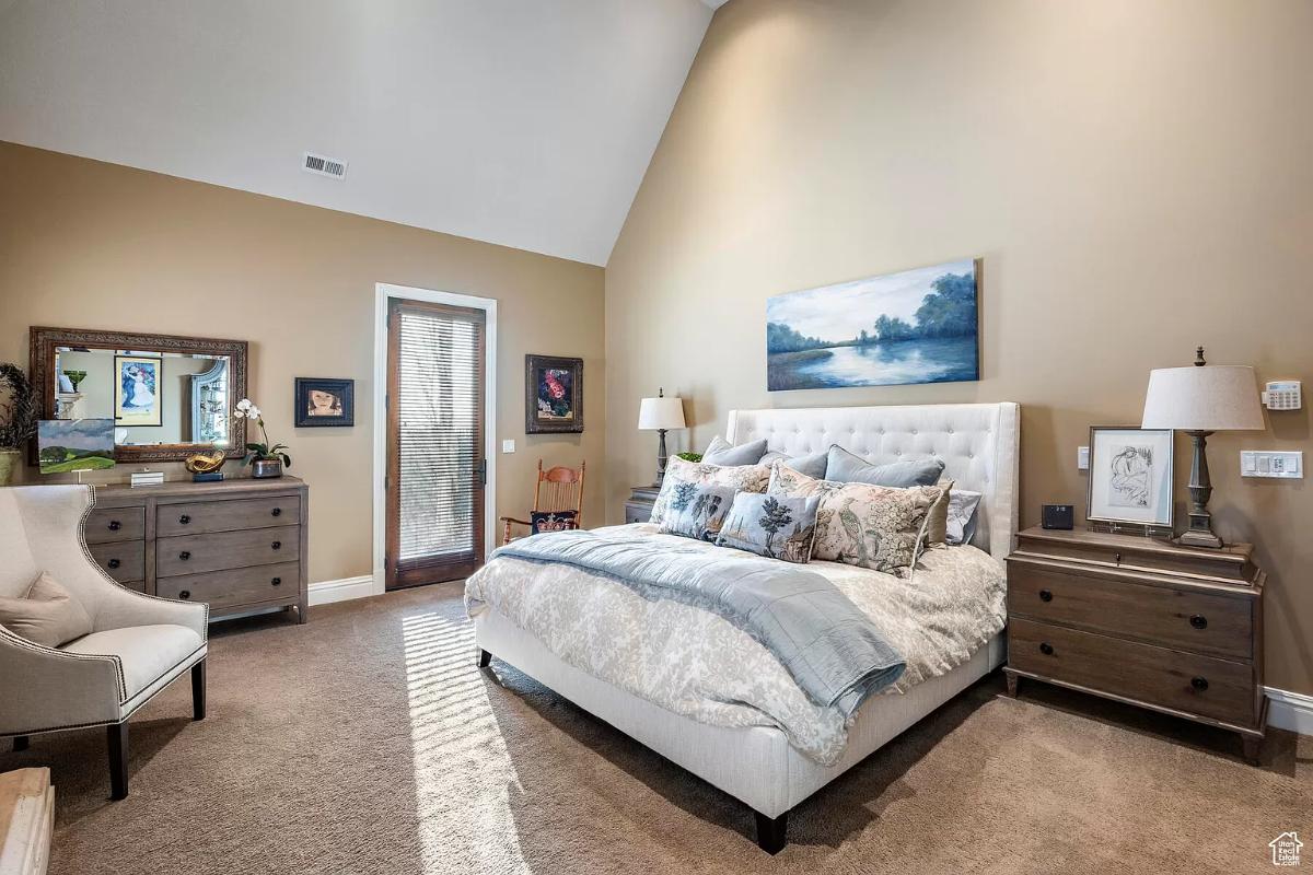 Bedroom with carpet flooring and a large bed.