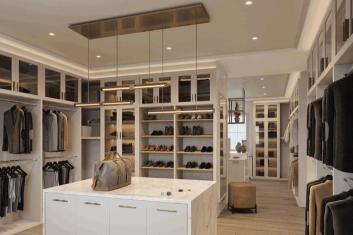 A walk-in closet with a center island, shelves, and cabinets.