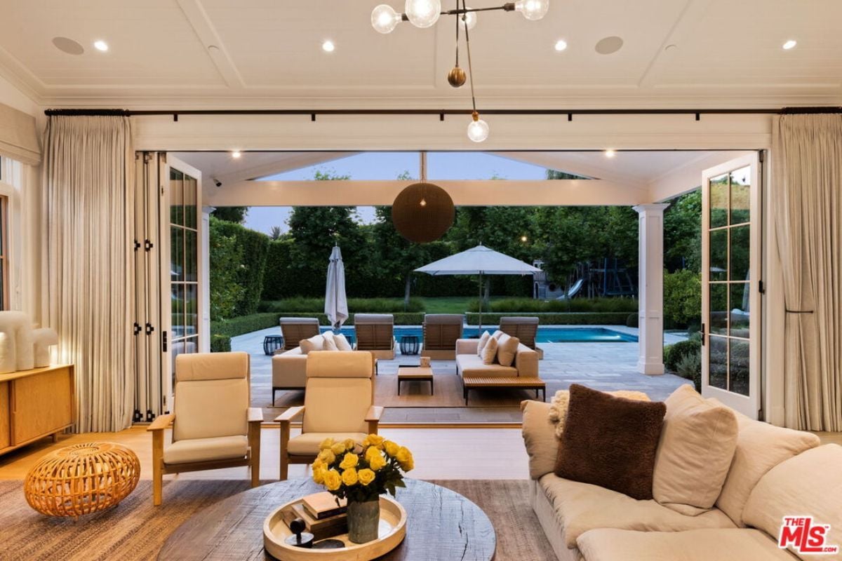 The living room is furnished with chairs, a couch, and a round center table.