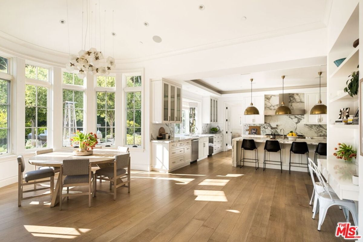 The kitchen includes countertops, stools, a sink, cabinets, and a breakfast nook.
